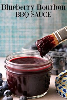 blueberry bourbon bbq sauce in a glass jar with a brush sticking out of it