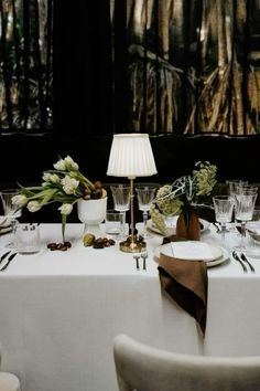 a white table topped with lots of plates and glasses