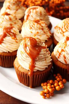 cupcakes with caramel drizzled on top and nuts scattered around them