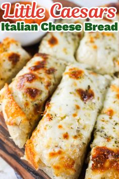 some cheese bread is cut into pieces and sitting on a cutting board with the words little caesars italian cheese bread