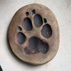 an animal's paw print on a wooden plate