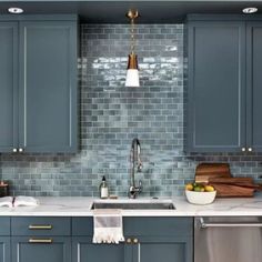 a kitchen with blue cabinets and white counter tops