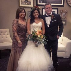 two women and a man in formal wear standing next to each other at a wedding