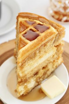 a piece of waffle cake on a plate with butter and syrup in the middle