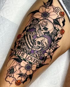 a woman's leg with a skull and flowers on it