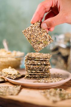 a stack of crackers on a plate being held up by someone's hand