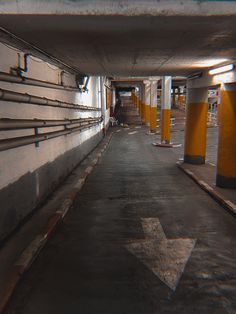 an empty parking garage with yellow and white pillars