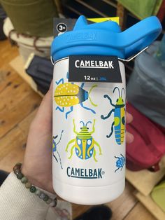 someone holding up a camelbak water bottle with bugs on it's side