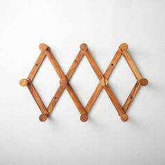 two wooden pegs are attached to the wall, one is shaped like a diamond