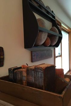 a wooden box filled with books on top of a table next to a window in a living room