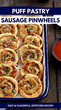 sausage pinwheels in a baking pan with dipping sauce on the side and text overlay that reads puff pastry sausage pinwheels