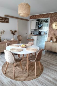 a dining room table with chairs and a rug on the floor in front of it