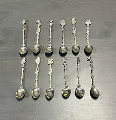 seven silver spoons are lined up on a table