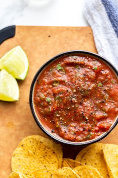 a bowl of salsa and tortilla chips on a cutting board