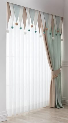 the curtains in this room are lined with blue and white pom - poms