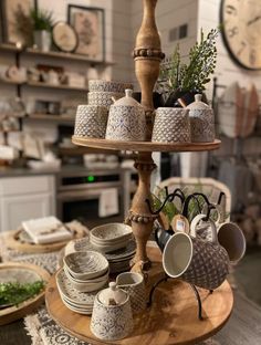 a wooden table topped with plates and cups