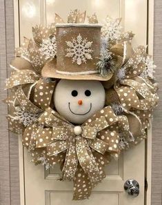 a snowman wreath with a top hat and bow tie on it's front door