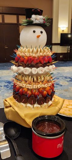 a cake made to look like a snowman sitting on top of a table with food