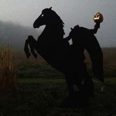 a statue of a horse with a pumpkin in it's mouth on a field