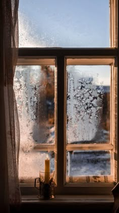 a window with frosted glass and a candle on the windowsill next to it