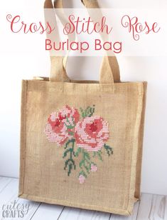 a cross stitch rose burlap bag on a white table with text overlay that reads, cross stitch rose burlap bag