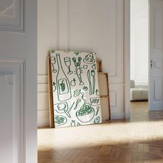 a green and white painting on the wall next to a wooden frame in an empty room