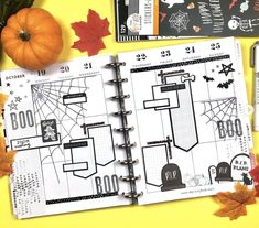 an open halloween planner with pumpkins and other items around it on a yellow background