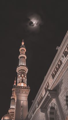 an image of a building at night with the moon in the sky