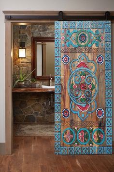 an open door to a bathroom with a painting on the wall and wood flooring