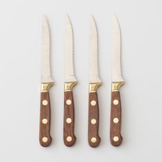 three knives with wooden handles are lined up against each other