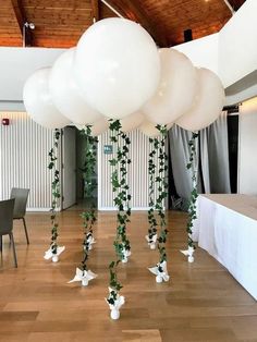 some white balloons are hanging from the ceiling