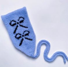 a blue knitted object with scissors on it's side and a string attached to the end