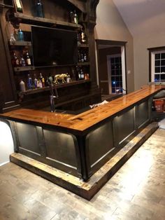 a bar in the middle of a room with shelves and cabinets on either side of it