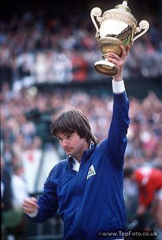 a man holding up a trophy in front of a crowd