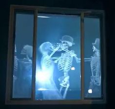 two skeletons are standing in front of a window with light coming through it and one skeleton is looking out the window