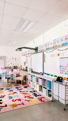 a classroom with lots of desks, chairs and a rug on the floor in front of it