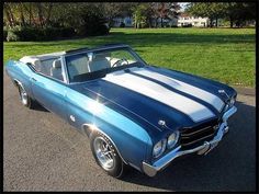 a blue and white muscle car parked on the street