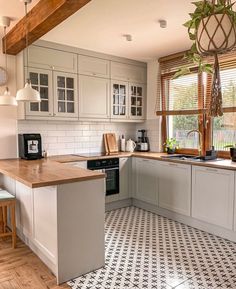 a kitchen with white cabinets and black and white checkered flooring on the tile