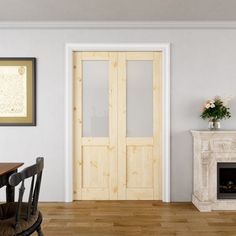 a room with a fireplace, table and chairs next to a door that has glass panels on it