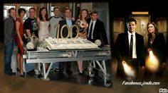 a group of people standing in front of a table with a cake and candles on it