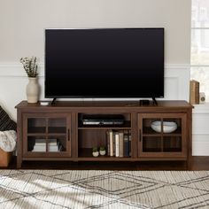 a flat screen tv sitting on top of a wooden entertainment center