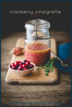 cranberry vinaigrete in a glass jar on a wooden cutting board