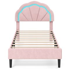 a pink bed with an ocean shell headboard and foot board on top of it