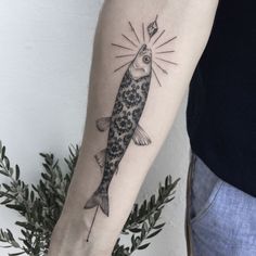 a fish tattoo on the left arm