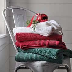 stack of folded towels sitting on top of a chair