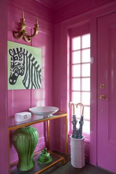 a bathroom with pink walls and green vases in front of the mirror on the wall