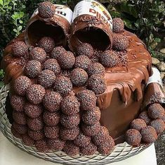 a cake with chocolate frosting and lots of strawberries on the top is sitting on a table