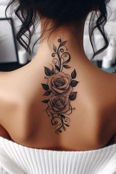 a woman's back neck tattoo with roses and leaves on the upper part of her neck