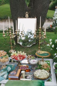 a table topped with lots of food next to a tree