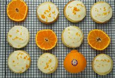 an assortment of oranges on a cooling rack with frosting and one cut in half